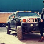 A rugged, masculine SUV driving off-road through a muddy terrain, showcasing its power and durability.