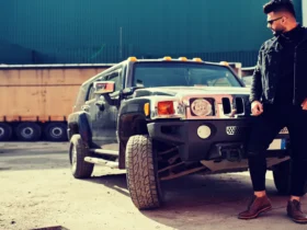 A rugged, masculine SUV driving off-road through a muddy terrain, showcasing its power and durability.